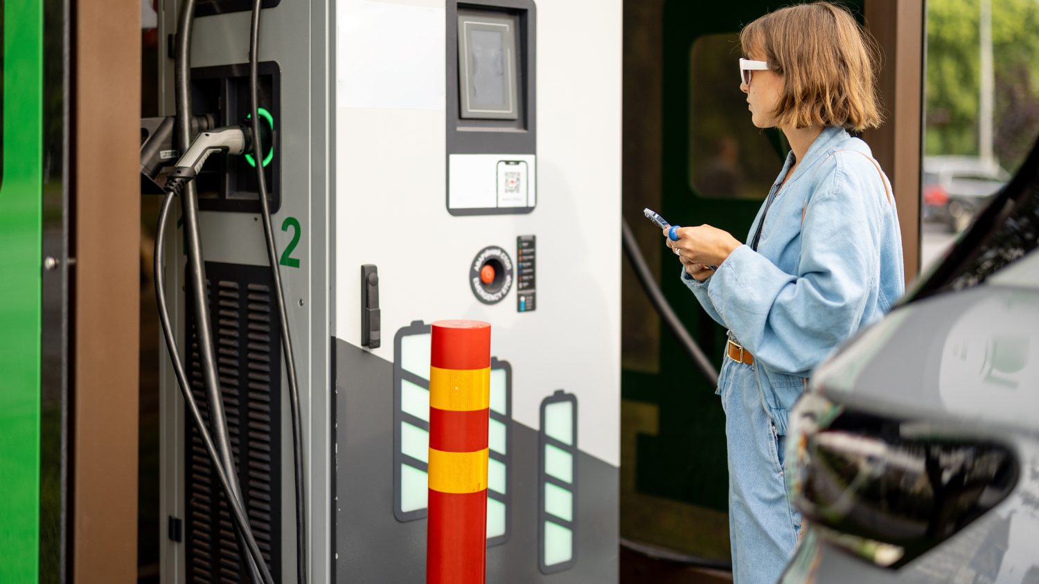 jeune femme devant une borne de recharge de niveau 3